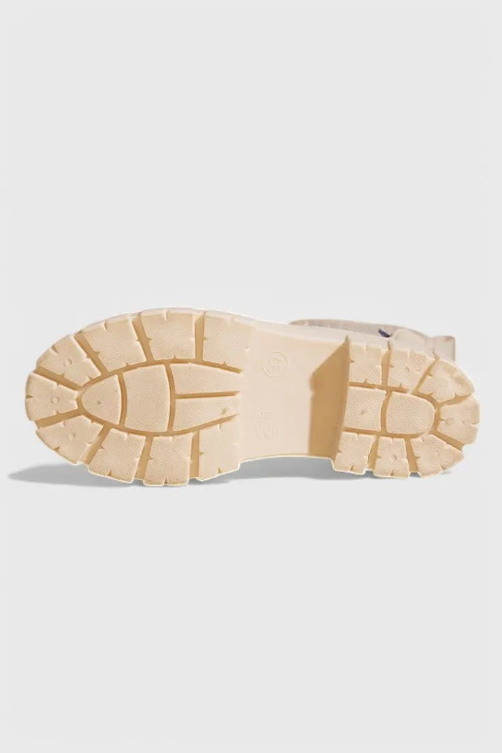 Cream rubber sole of Chelsea rain boot showing chunky lugged tread