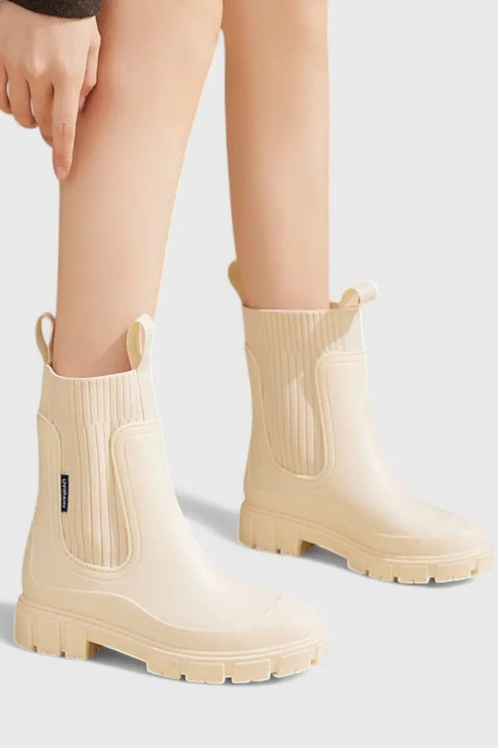 Cream waterproof Chelsea boots worn on model with ribbed ankle cuff