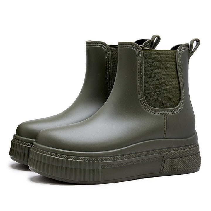 Pair of olive green waterproof Chelsea boots showing platform sole from behind