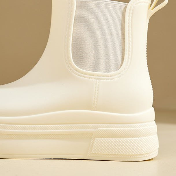 Close-up of cream Chelsea boot heel showing elastic panel and ribbed platform
