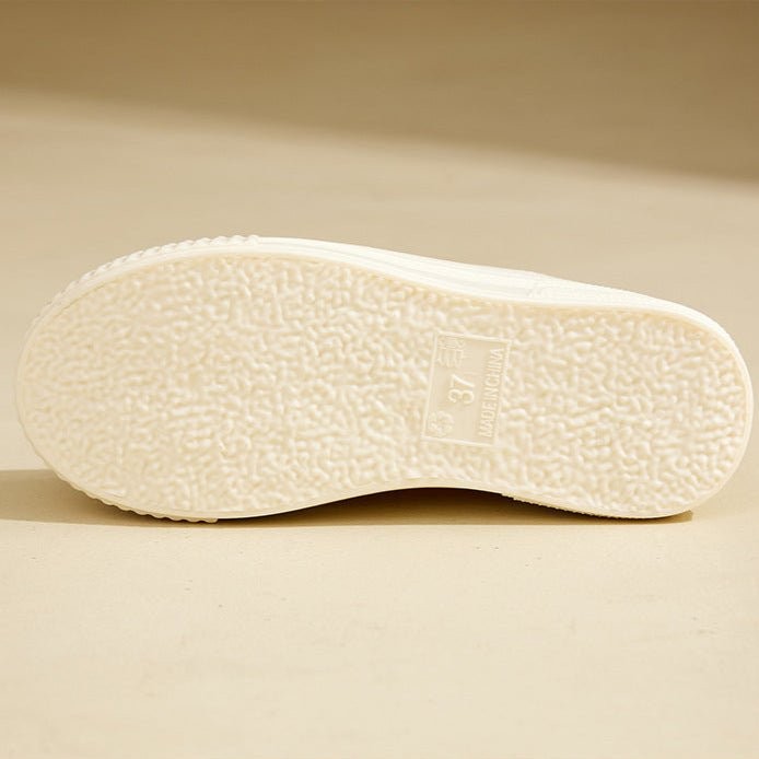 Underside view of cream rain boot sole showing textured tread pattern