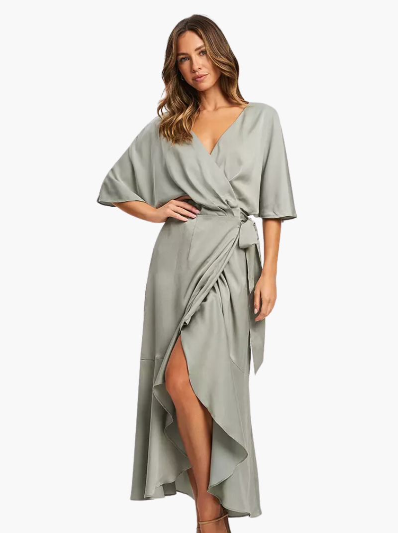 Model wears sage green wrap dress with V-neck and asymmetric hemline