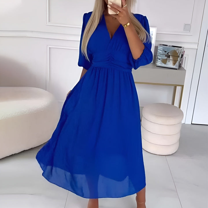 Cobalt blue V-neck midi dress featuring a cinched waist and flowing skirt