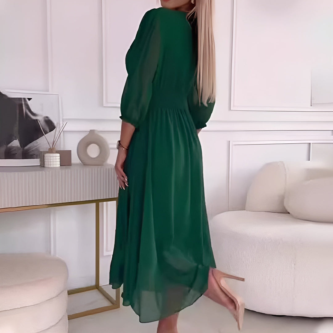 Emerald green midi dress showing flowing skirt and ruched back detail