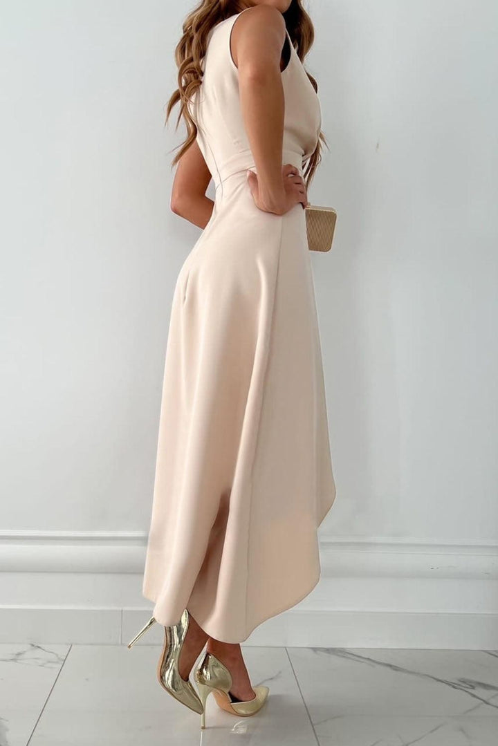 Side view of nude sleeveless wrap dress with flowing high-low skirt